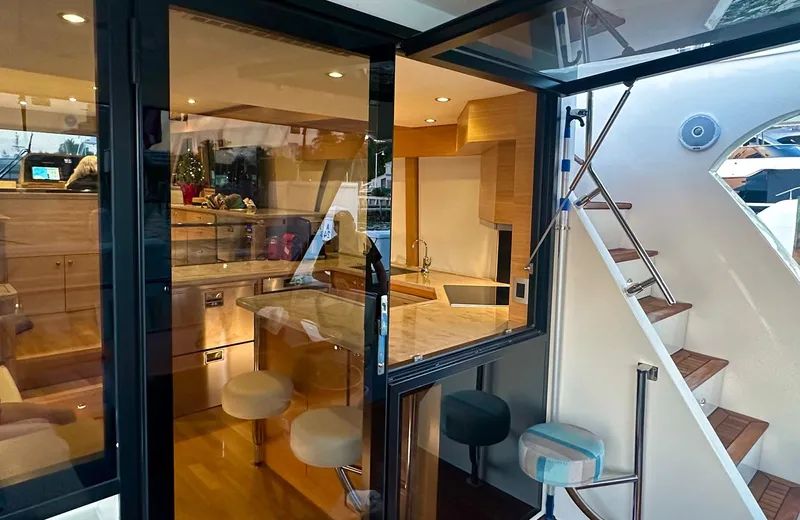 Oasis Yacht Photos Pics Luxurious interior of 2021 Outer Reef Trident 620 yacht with modern kitchen and seating.