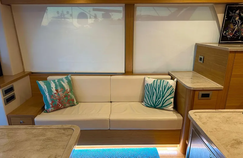 Oasis Yacht Photos Pics Luxurious interior of 2021 Outer Reef Trident 620 yacht with elegant seating and decorative pillows.