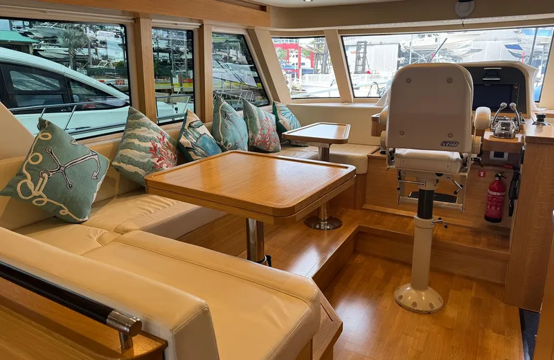Oasis Yacht Photos Pics Luxurious interior of 2021 Outer Reef Trident 620 yacht with seating and helm.