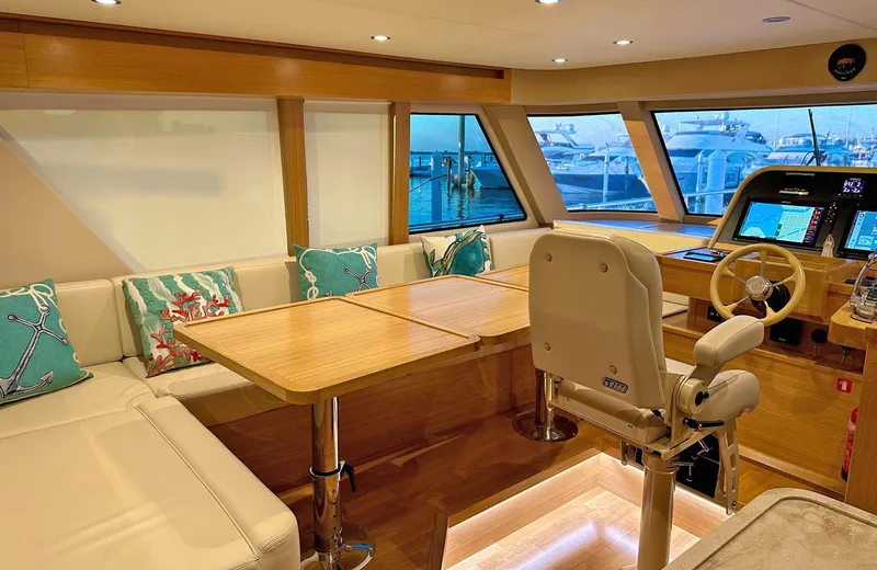 Oasis Yacht Photos Pics Luxurious interior of 2021 Outer Reef Trident 620 yacht with helm and seating area.