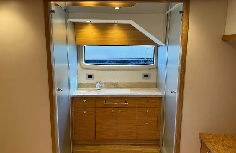 Oasis Yacht Photos Pics 2021 Outer Reef Trident 620 yacht interior with modern wooden cabinetry and sleek design.