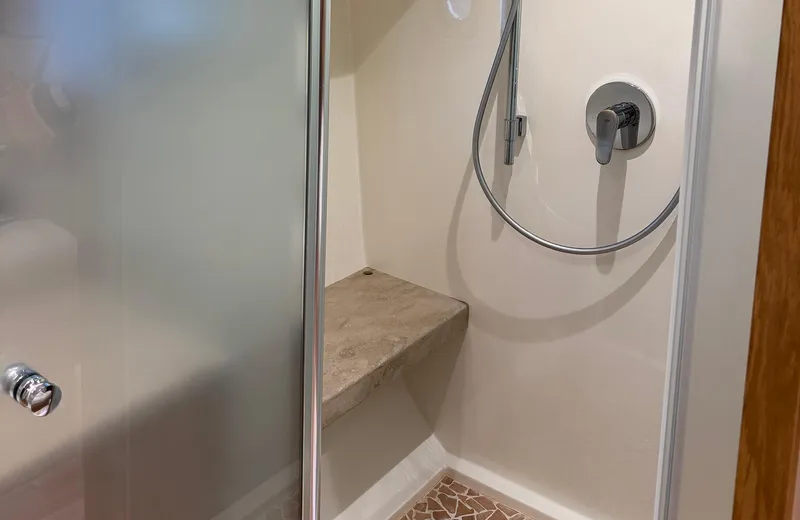 Oasis Yacht Photos Pics Shower area in 2021 Outer Reef Trident 620 yacht with bench and handheld showerhead.