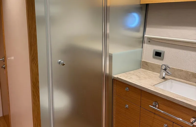 Oasis Yacht Photos Pics 2021 Outer Reef Trident 620 yacht bathroom with frosted glass shower and wooden cabinetry.