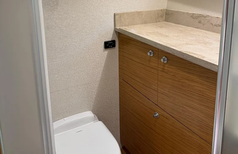Oasis Yacht Photos Pics Modern bathroom interior on 2021 Outer Reef Trident 620 yacht, featuring wooden cabinetry and sleek design.