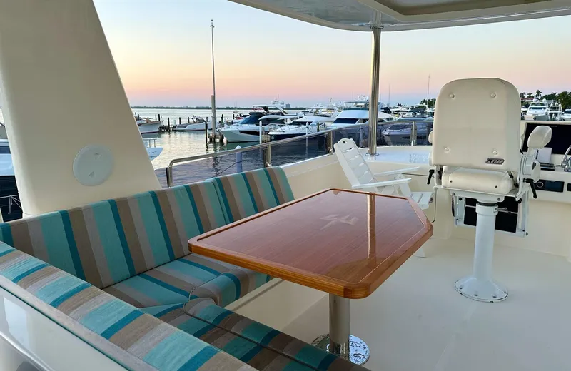 Oasis Yacht Photos Pics Luxurious 2021 Outer Reef Trident 620 yacht interior with striped seating and marina view.
