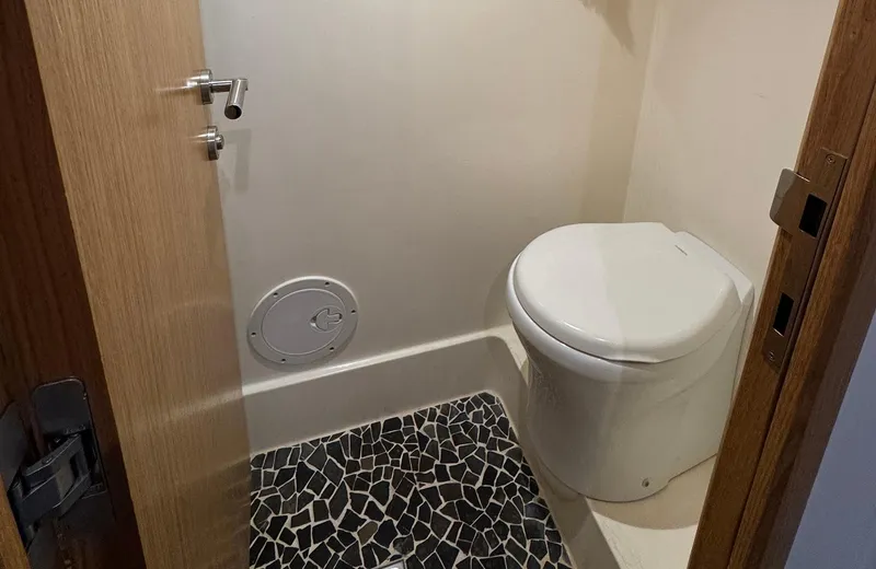Oasis Yacht Photos Pics Compact bathroom with modern toilet and mosaic floor on 2021 Outer Reef Trident 620 yacht.