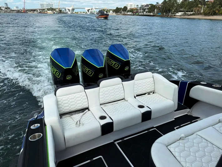  Yacht Photos Pics 2024 Statement 350 Open boat with triple engines cruising on a scenic waterway.