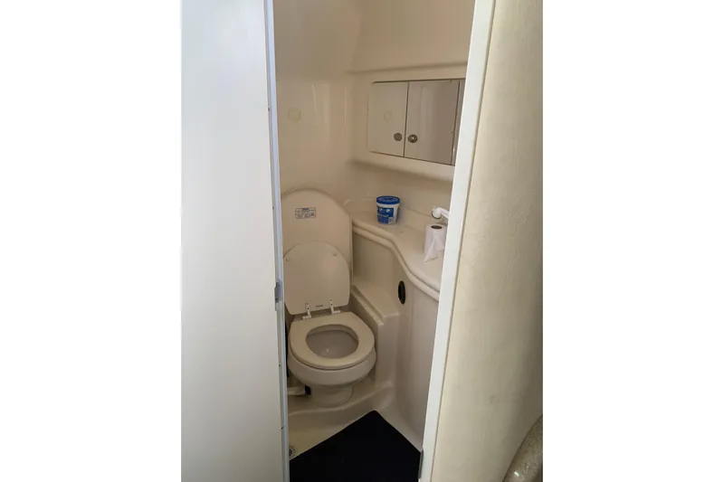 Maximus Yacht Photos Pics 2005 Sea Ray 340 Sundancer bathroom with toilet, storage cabinets, and essential amenities.