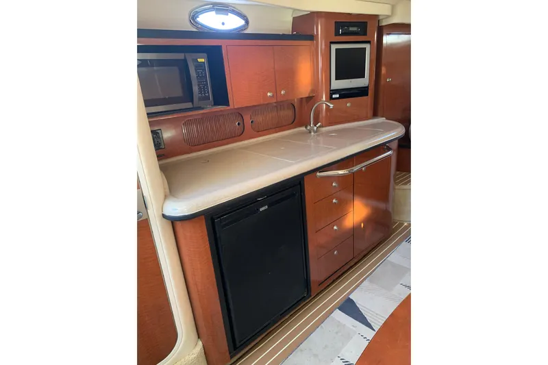 Maximus Yacht Photos Pics 2005 Sea Ray 340 Sundancer yacht kitchen with microwave, sink, and wood cabinetry.