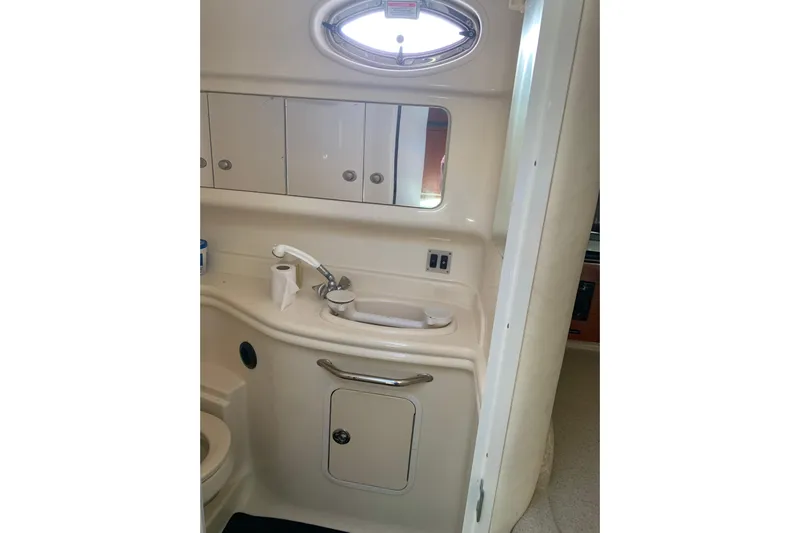 Maximus Yacht Photos Pics 2005 Sea Ray 340 Sundancer bathroom with sink, mirror, and storage cabinets.