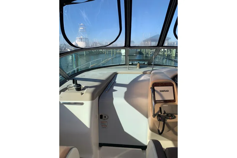Maximus Yacht Photos Pics 2005 Sea Ray 340 Sundancer cockpit with Simrad navigation, marina view through windshield.