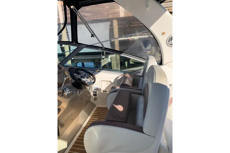 Maximus Yacht Photos Pics 2005 Sea Ray 340 Sundancer cockpit with steering wheel and comfortable seating.