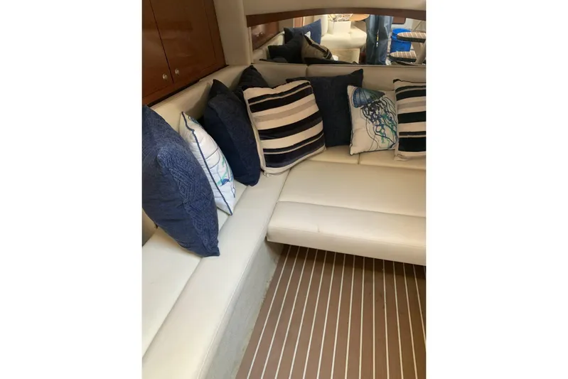 Maximus Yacht Photos Pics Interior of 2005 Sea Ray 340 Sundancer with striped and patterned cushions on white seating.