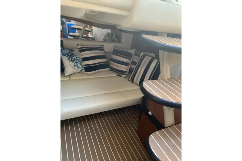 Maximus Yacht Photos Pics Interior of 2005 Sea Ray 340 Sundancer with striped cushions and wooden steps.