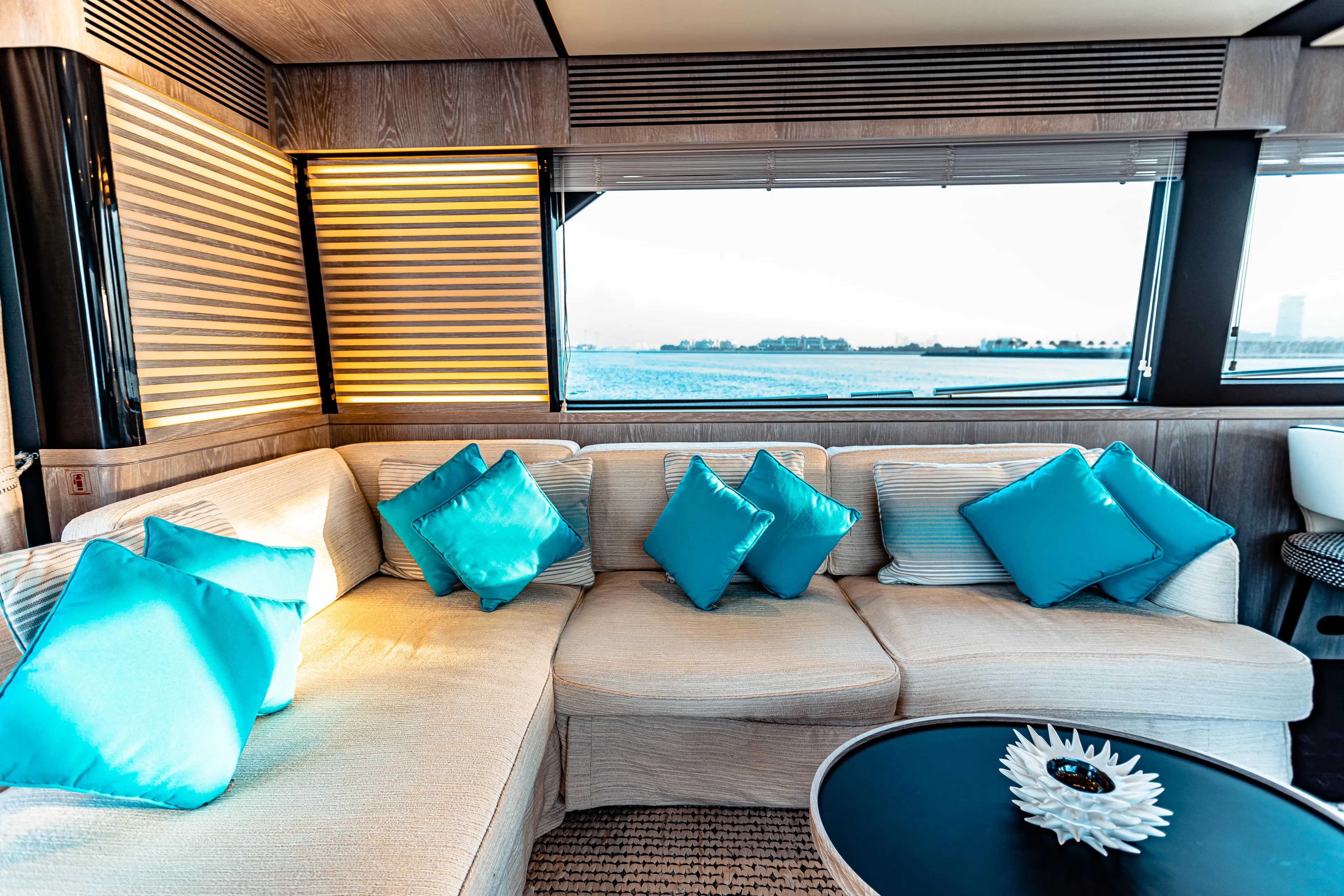 Fat Boy Yacht Photos Pics Luxurious interior of 2020 Azimut Magellano 66 yacht with turquoise cushions and sea view.