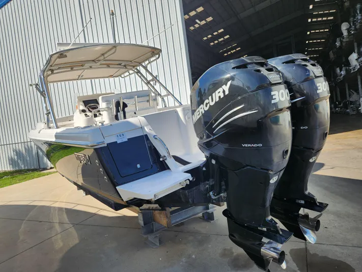  Yacht Photos Pics 2008 Intrepid 323 Cuddy with dual Mercury 300 Verado engines, docked near a large warehouse.