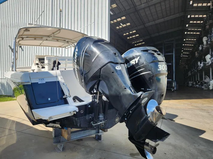  Yacht Photos Pics 2008 Intrepid 323 Cuddy with dual Mercury 300 engines, docked near a large storage facility.