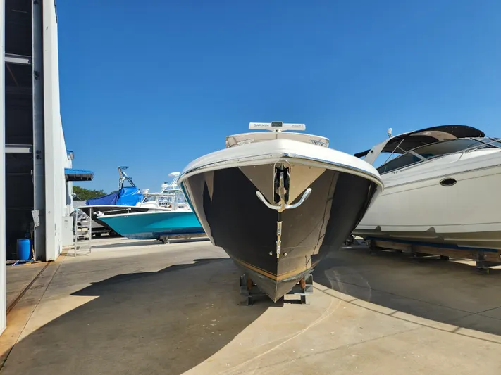  Yacht Photos Pics 2008 Intrepid 323 Cuddy boat in a marina, clear blue sky background.