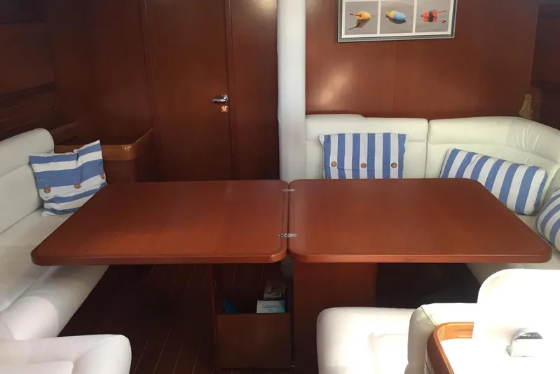 Perseverance Yacht Photos Pics Luxurious 2012 Grand Soleil 43 yacht interior with wooden table and striped cushions.