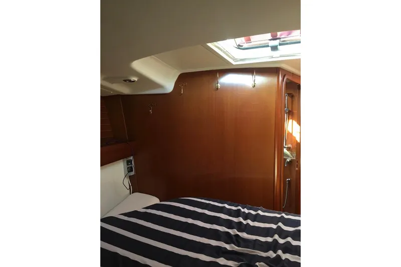 Perseverance Yacht Photos Pics Interior cabin of 2012 Grand Soleil 43 yacht with striped bedding and wooden paneling.