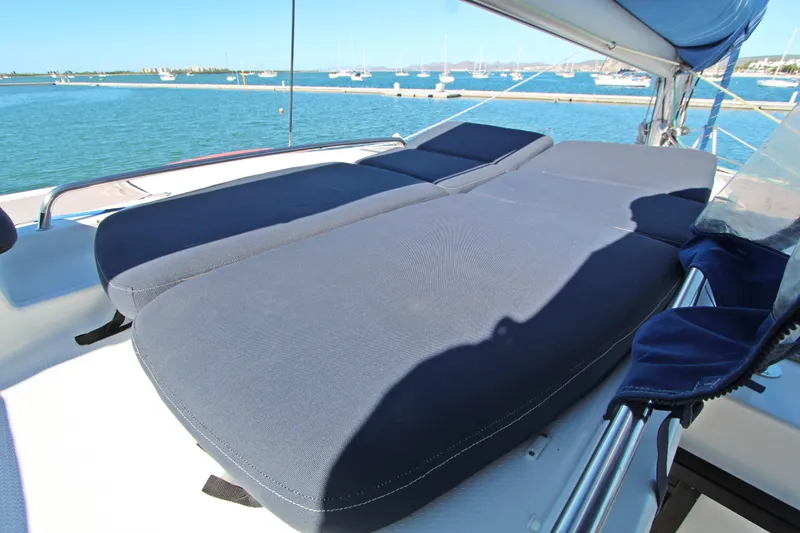 Yacht Photos Pics 2013 Fountaine Pajot Helia 44 catamaran with blue cushioned deck seating, docked in a marina.