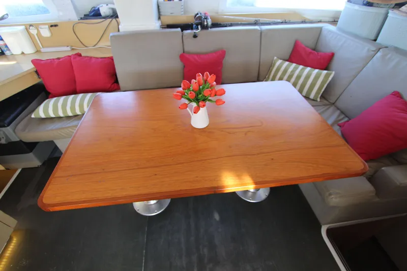  Yacht Photos Pics Interior of 2013 Fountaine Pajot Helia 44 with wooden table and colorful cushions.
