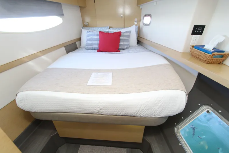  Yacht Photos Pics Cozy cabin interior of 2013 Fountaine Pajot Helia 44 catamaran with comfortable bed and porthole view.