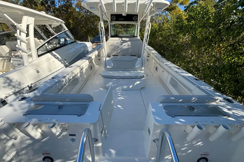 Wcn 57599 325cc Yacht Photos Pics 2025 World Cat 325 CC boat interior with seating and storage, surrounded by greenery.