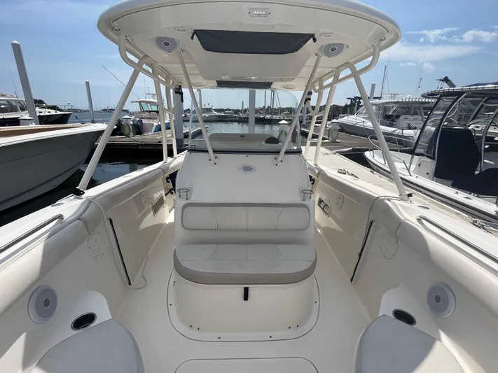  Yacht Photos Pics 2011 Pursuit S 280 Sport boat interior at marina, featuring seating and helm.