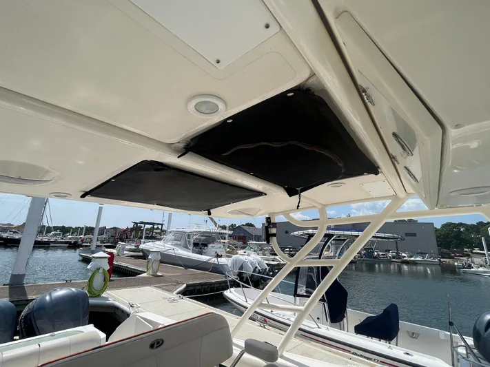  Yacht Photos Pics 2011 Pursuit S 280 Sport boat interior at marina, featuring seating and storage.