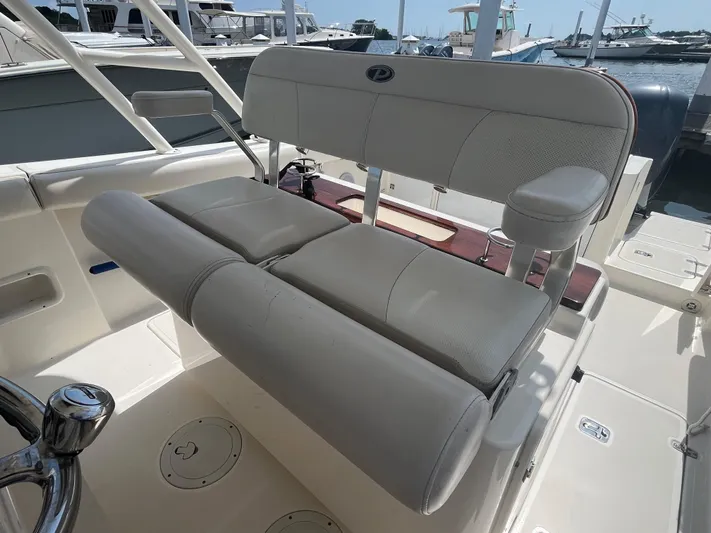  Yacht Photos Pics 2011 Pursuit S 280 Sport boat seating area with cushioned bench and armrest.