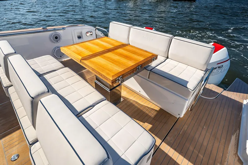 Available Now Yacht Photos Pics Luxury seating area on 2025 Pardo Yachts 38, featuring elegant wooden table and cushioned benches.