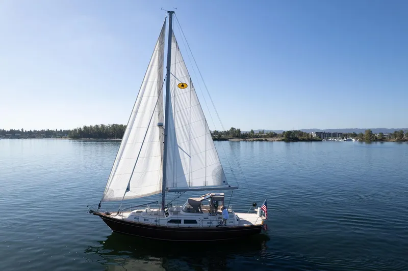Easy Going Yacht Photos Pics 2008 Island Packet 465 sailboat cruising on calm waters under clear blue skies.