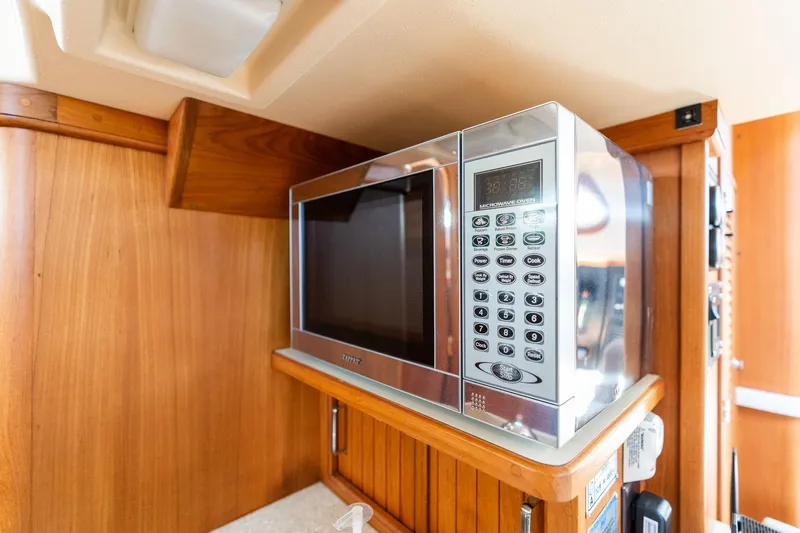 Easy Going Yacht Photos Pics Microwave oven in 2008 Island Packet 465 yacht interior, featuring wooden cabinetry.