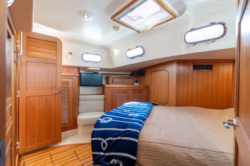 Easy Going Yacht Photos Pics Luxurious 2008 Island Packet 465 yacht cabin with wood interior and cozy bedding.