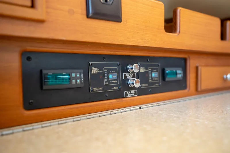 Easy Going Yacht Photos Pics Control panel on 2008 Island Packet 465 yacht, featuring wooden cabinetry and modern switches.