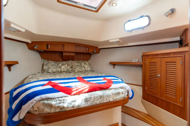 Easy Going Yacht Photos Pics Cozy cabin interior of 2008 Island Packet 465 yacht with bed and wooden cabinetry.