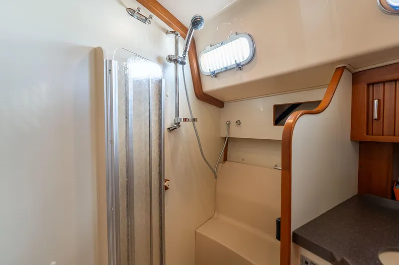 Easy Going Yacht Photos Pics 2008 Island Packet 465 yacht bathroom with shower, wooden accents, and compact design.