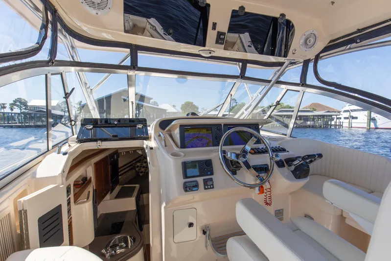  Yacht Photos Pics 2009 Grady-White 330 Express boat cockpit with steering wheel and navigation equipment.