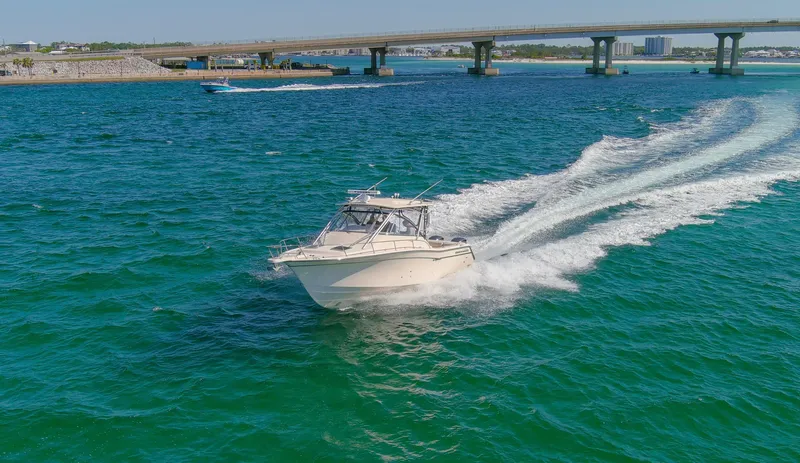  Yacht Photos Pics 2009 Grady-White 330 Express boat cruising on blue water near a bridge.