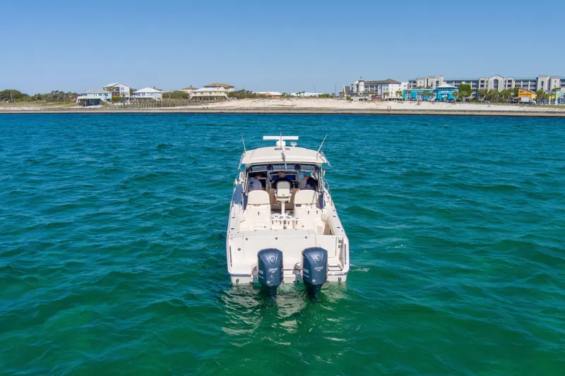  Yacht Photos Pics 2009 Grady-White 330 Express boat on blue water near coastal buildings.