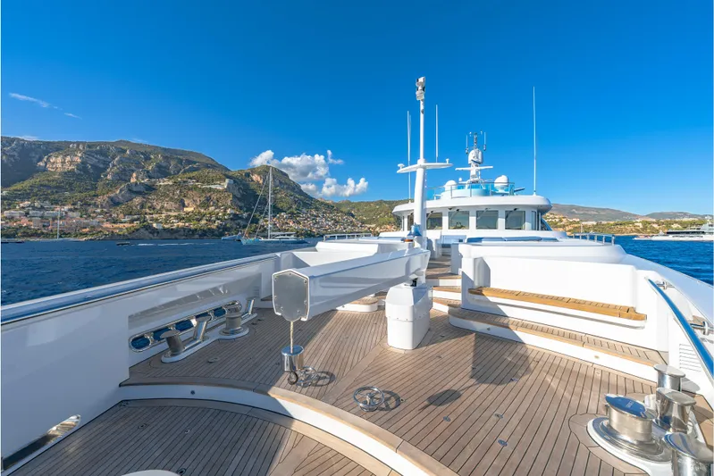 Latitude Yacht Photos Pics Luxurious 2009 Timmerman Expedition Tri-Deck yacht cruising near scenic coastal mountains.