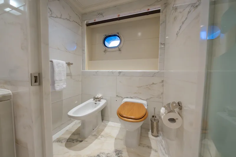 Latitude Yacht Photos Pics Luxurious marble bathroom on 2009 Timmerman Expedition Tri-Deck yacht with porthole window.