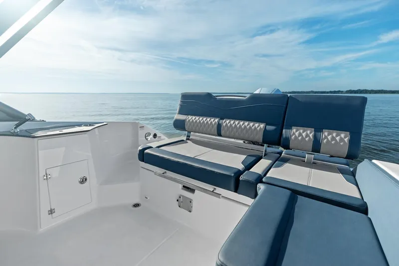  Yacht Photos Pics Manufacturer Provided Image: 2026 Monterey Elite 25 OB boat interior with blue and white seating, overlooking calm waters.
