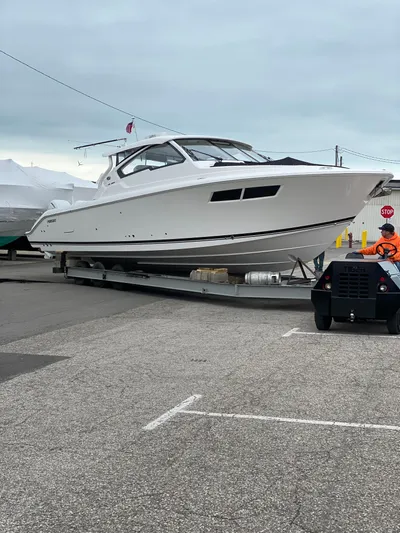  Yacht Photos Pics 2022 Pursuit DC 365 boat on a trailer at a marina.