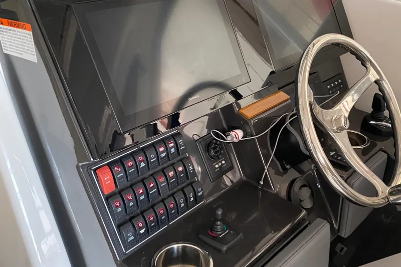  Yacht Photos Pics 2022 Pursuit DC 365 boat dashboard with dual screens and control panel.