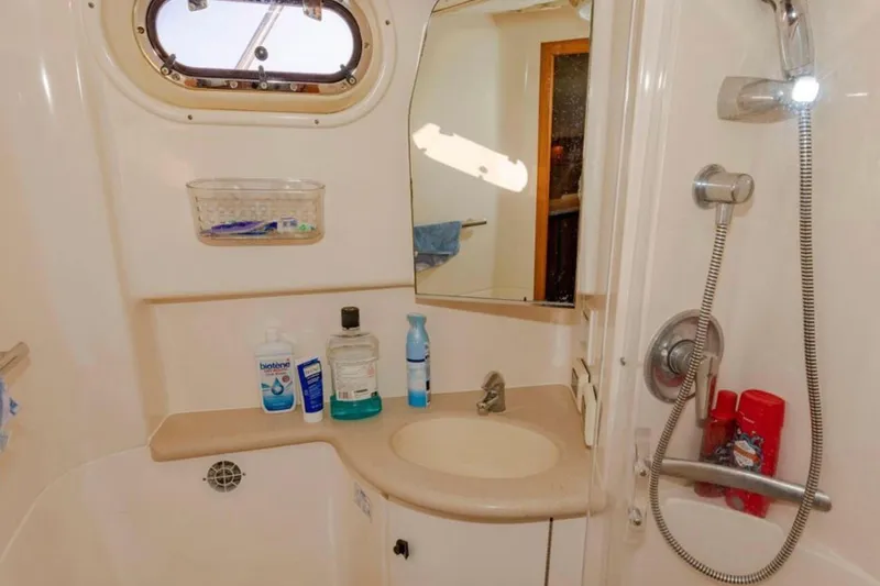 Brown Eyed Girl Yacht Photos Pics 2004 Pursuit 3800 Express boat bathroom with sink, mirror, and showerhead.