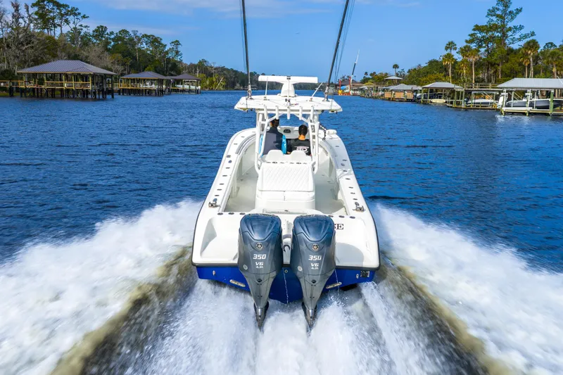  Yacht Photos Pics 2014 Yellowfin 32 Offshore boat cruising on a scenic waterway with dual engines.