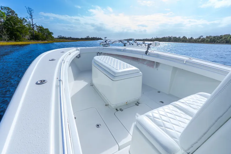  Yacht Photos Pics 2014 Yellowfin 32 Offshore boat interior with white seating on a calm waterway.