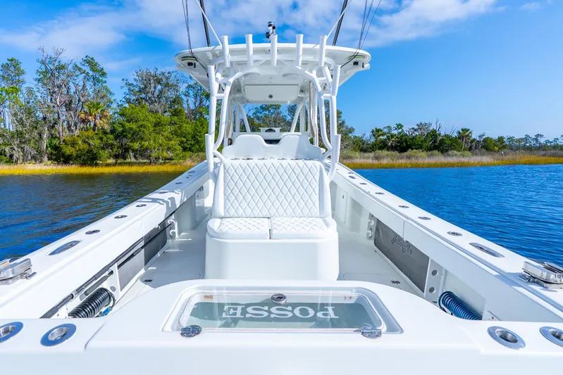  Yacht Photos Pics 2014 Yellowfin 32 Offshore boat on calm water, featuring sleek white design and spacious seating.